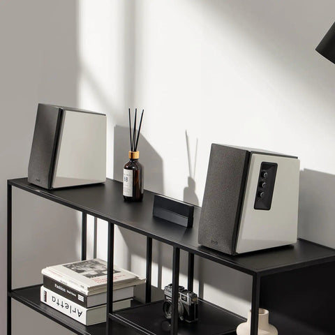 R1700BT Bluetooth Bookshelf Speakers With 66W RMS Power on display in a sleek white wood enclosure on a black shelf