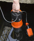 Person holding 1HP Submersible Sump Pump With Automatic Float Switch, 3700GPH Clean Or Dirty Water Pump for flooded cellar, orange.