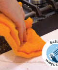 Cleaning a stove gap with a cloth, featuring Stove Gap Cover And Crumb Guard Silicone 20.5 Inch By 2.3 Inch Matte Black Pack Of 2.