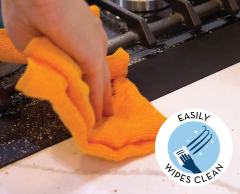 Cleaning a stove gap with a cloth, featuring Stove Gap Cover And Crumb Guard Silicone 20.5 Inch By 2.3 Inch Matte Black Pack Of 2.