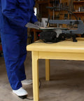 User operating Heavy Duty 10 Foot Momentary Foot Switch Pedal Controller with a power tool at a workshop.