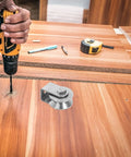 Close-up of a Heavy Duty Stainless Steel Pulley Wheel Track Roller For Sliding Doors And Gates Built Different With Zero Noise Vibes Smooth Glide Performance Handles Heavy Loads On Wire Rope Systems Top Tier, being drilled into wooden surface.