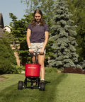 Person using 2600A-PLUS Fertilizer Spreader with 40Lb hopper and beefy all terrain pneumatic tires on a lawn.