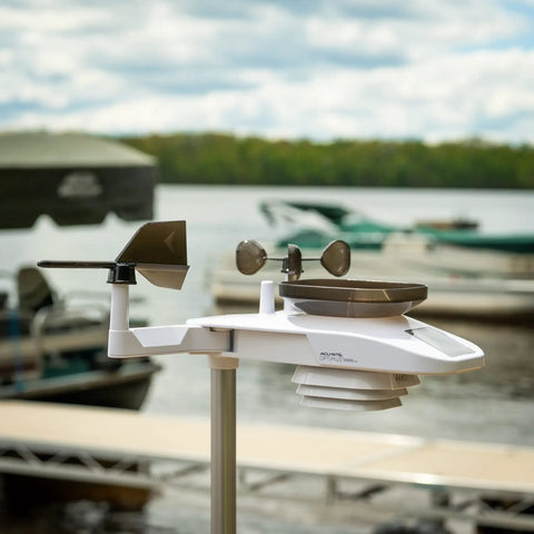 Side view of Optimus Weather Station With WiFi HD Display Solar Power Pack Lightning Detection Indoor Outdoor Temperature And Humidity Wind Speed And Direction Rainfall Measurements For Hyperlocal Readings installed by a lake.