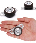 Hand holding a 1.25-inch caster from 8 Pack One And One Quarter Inch Low Profile Fixed Side Mount Casters Wheels For Furniture Underbed Cabinets Non Swivel Drawer Rollers Rigid Small Wheels Space Saving Design Load 36 Lb Each Easy Glide Replacement