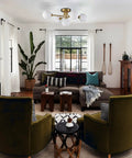 Gold Sputnik Ceiling Light Fixture With Globe Shades in modern living room with green chairs and large window