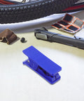 TEHAUX bike hydraulic brake hose cutter tool, blue plastic, on a workbench with a tire and repair accessories
