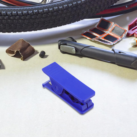 TEHAUX bike hydraulic brake hose cutter tool, blue plastic, on a workbench with a tire and repair accessories