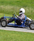 Person driving a blue go kart on a track, showcasing the Premium 4X4 Go Kart Live Axle Hubs 2 Pack.