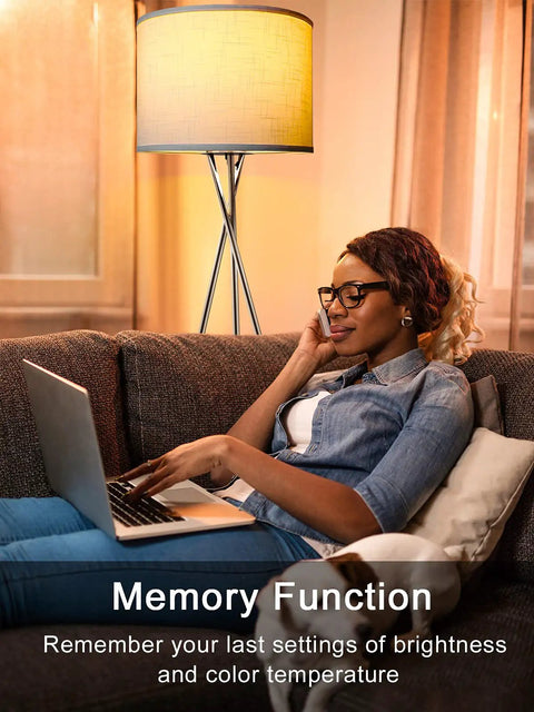 Person relaxing with a laptop near Tripod Floor Lamp With Remote And Touch Control, LED 3 Color Temperatures, White Finish, Mid Century Design