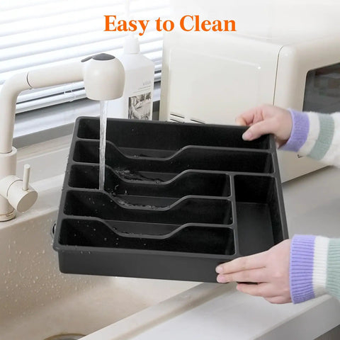 Sturdy Silverware Organizer With Lid For Drawer Or Countertop being rinsed under a kitchen faucet, black plastic tray