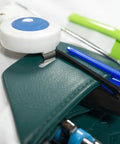 Close-up of Spruce Green Faux Leather Lab Coat Pocket Protector holding pens, tweezers, and small tools.