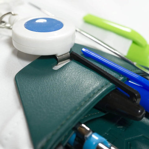 Close-up of Spruce Green Faux Leather Lab Coat Pocket Protector holding pens, tweezers, and small tools.