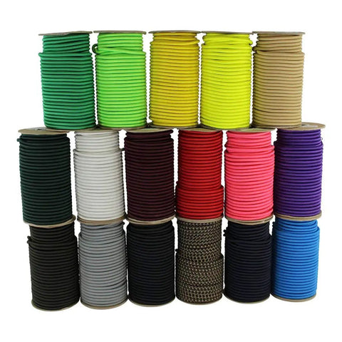 Multiple colors of bungee cord spools, including green, white, black, and more, arranged in a neat stack.