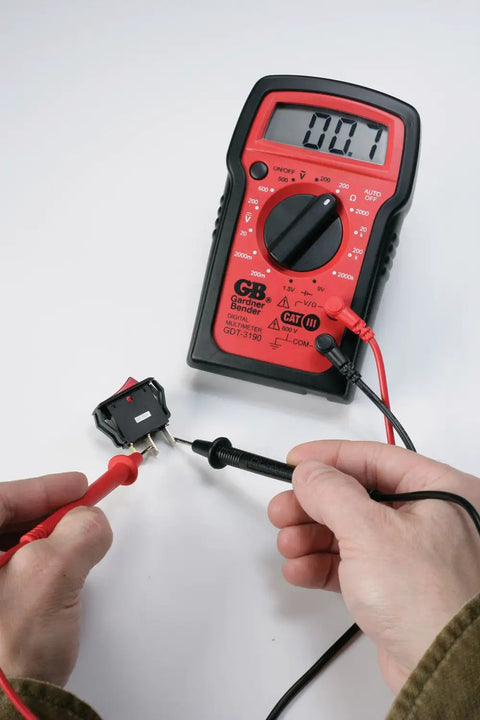 Hands using Digital Multimeter 4 Function 14 Range For AC DC Voltage Resistance And Battery Testing Manual Ranging Auto Off Durable Drop Resistant Housing Three And A Half Digit Display With Secure Input Jacks Must Have Toolbox Essential to test voltage.
