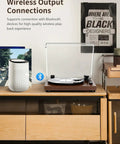 Bluetooth Turntable Player With Built In Phono Preamp And Magnetic Cartridge Belt Drive Records Player 2 Speed Vinyl Record Deck on a table with a wireless speaker.