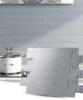Peel and Stick Aluminum Backsplash Tiles for Kitchen, 10-Piece Silver Brushed Subway Tile Set next to modern stove