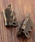 Close-up of 40 Pcs Mini Butterfly Door Hinges Set in Antique Bronze, ultra lightweight, 20x25mm, decorative for DIY projects.