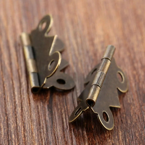 Close-up of 40 Pcs Mini Butterfly Door Hinges Set in Antique Bronze, ultra lightweight, 20x25mm, decorative for DIY projects.