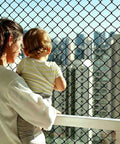 Kid and Pup Safe Rope Net for Balcony Railings with adult and child, city view, knotless polyester safety netting visible