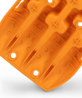 Close-up of orange nylon Beefed Up Off Road Recovery Traction Tracks For Sand Snow Mud 4x4 Vehicles with U shaped grip design.