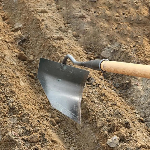 Workhorse Triangle Hoe Garden Tool With Hardened Steel Plow Head in soil, used for digging, weeding, and planting.