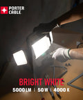 Person assembling Heavy Duty 50W LED Work Light With Three Head Stand Portable Corded for construction and garage use, 5000 lm.