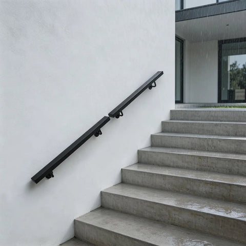 Heavy Gauge Wall Mount Stair Handrail In Matte Black Stainless Steel For Indoor Outdoor Stairs on concrete steps with rain.