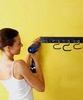 Installation of 64 Inch Garage Storage Organizer Wall Mount For Tools And Cleaning Essentials with drill by a woman.
