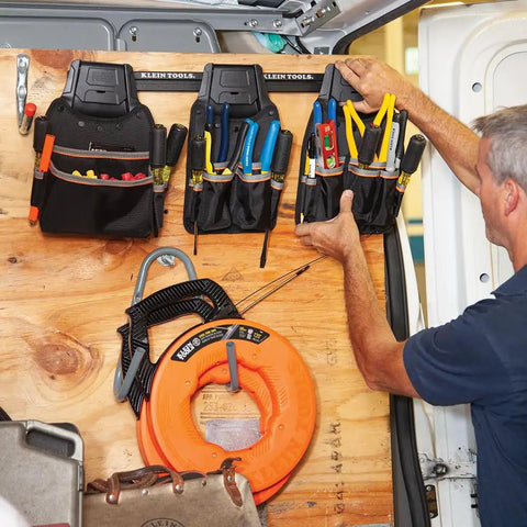 Tradesman Pro Modular Drill Pouch with Belt Clip attached to wall rack, storing various tools in durable 1680D ballistic weave pouches.