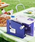 No Sweat Heavy Duty Bag Sealer With Razor Edge Trimmer And Six Pack Assorted Color Rolls on table with snacks and packaging.