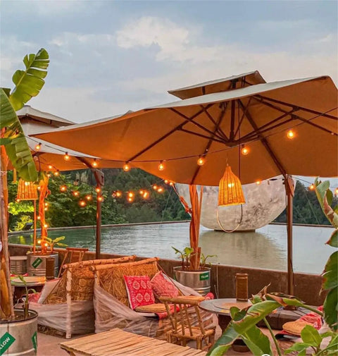 Outdoor 240 Ft LED String Lights With 124 G40 Globe Bulbs illuminating a patio with umbrellas and plants