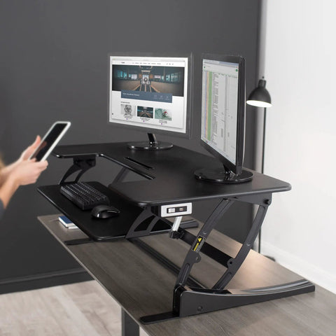 Electric Height Adjustable Desk Converter With Sit To Stand Function And Dual Monitor Riser 42 Inch Workstation Stand Up Desk With USB Port Black Finish No Fuss Electric Lift For Home Office in use with two monitors and keyboard