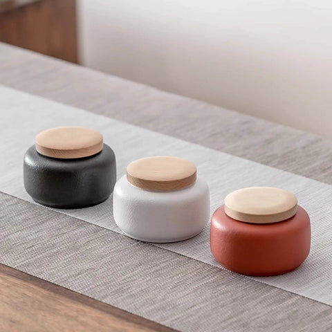 Elevate Your Kitchen Stash With These Top Shelf Ceramic Tea Canisters Featuring Snug Wooden Lids And Durable Porcelain Jars Perfect For Keeping Coffee Beans Sugar Or Salt Fresh As Ever Set Of 4, three canisters displayed.