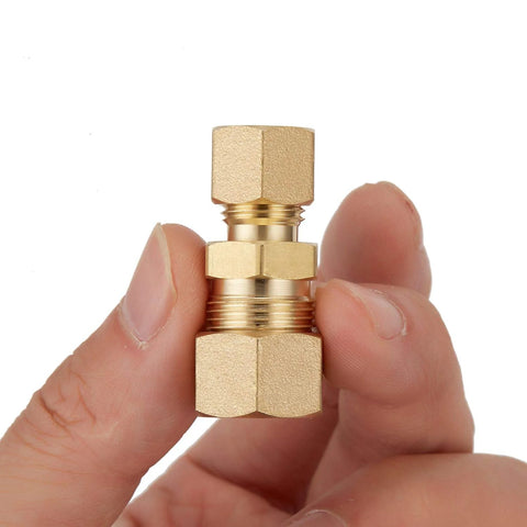 Brass compression union fitting 3/8 in x 1/4 in tube OD held in hand