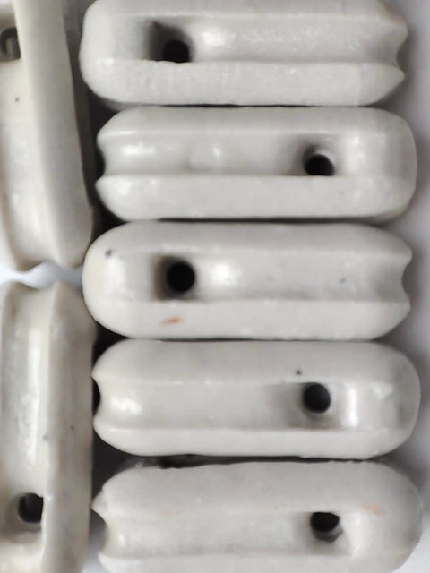 Close-up of a 22 pack of glazed ceramic antenna insulators for dipole, inverted Vee, end-fed and long-wire antennas.