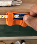Magnetic Soldering Jig With Nano Suction Base holding LED strip for wiring on a wooden surface.