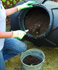 Person using 170L Outdoor Compost Bin With Wheels, 360 Degree Rotating Drum For Effortless Turning And Aeration in garden