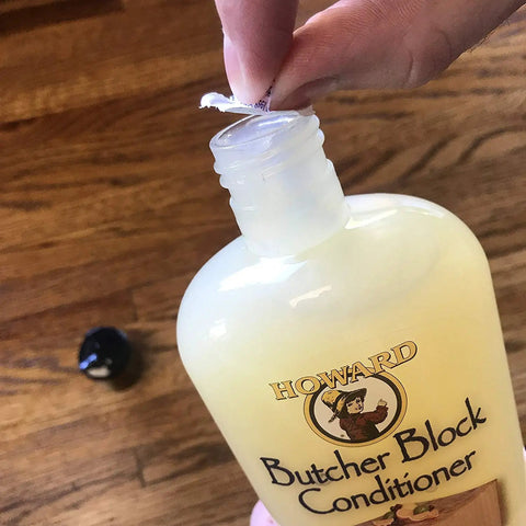 Close-up of person opening Butcher Block Conditioner 12 Ounce 5 Pack For Wood Countertops And Cutting Boards, Food Safe Oil Treatment.