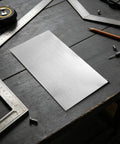 Six-Piece Bendable Aluminum Sheets For Crafting And DIY Projects, thin metal blank on workbench with tools