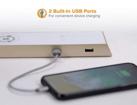 Close-up of a dimmable black desk lamp with wireless charging pad and dual USB ports, showing phone charging via USB.