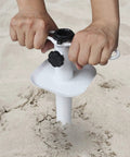 Hands installing Heavy Duty Beach Umbrella Sand Anchor Ground Screw Auger With Carry Bag Universal Fit For High Winds in sand