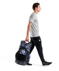 Person carrying All Set Multisport Swim Backpack for Gym and Training 45L Large Capacity Rucksack with blue pattern.