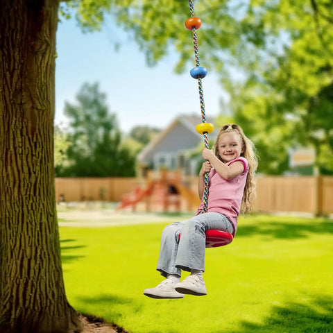 Child enjoying Red Disc Seat Swing For Kids with Easy Install Rainbow Climbing Rope Carabiner and 4 Foot Strap in backyard