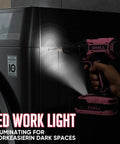 Pink 247-Piece 20V Cordless Drill Kit with LED light illuminating a dark space, held next to a black appliance for DIY repairs