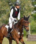 Equestrian rider on horse using Bow Balance Stirrup Pads in Stainless Steel for Pro Riders, 12cm Long, durable upgrade in motion