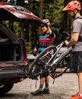 XTC2 Tilt Hitch Mount Bike Rack For Two Bikes With Platform Carrier on SUV being used by two cyclists in forested area
