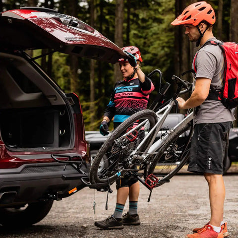 XTC2 Tilt Hitch Mount Bike Rack For Two Bikes With Platform Carrier on SUV being used by two cyclists in forested area
