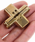 Hand holding Hidden Cross Hinge Set Four Pcs Alloy Invisible Cabinet Door Hinges 1.64 by 1.3 Inches Silent Concealed Mount