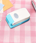 Dope Tiny Paper Punch Hole Puncher For Scrapbooking And Photo Albums on pink checkered surface with colorful paper sheets